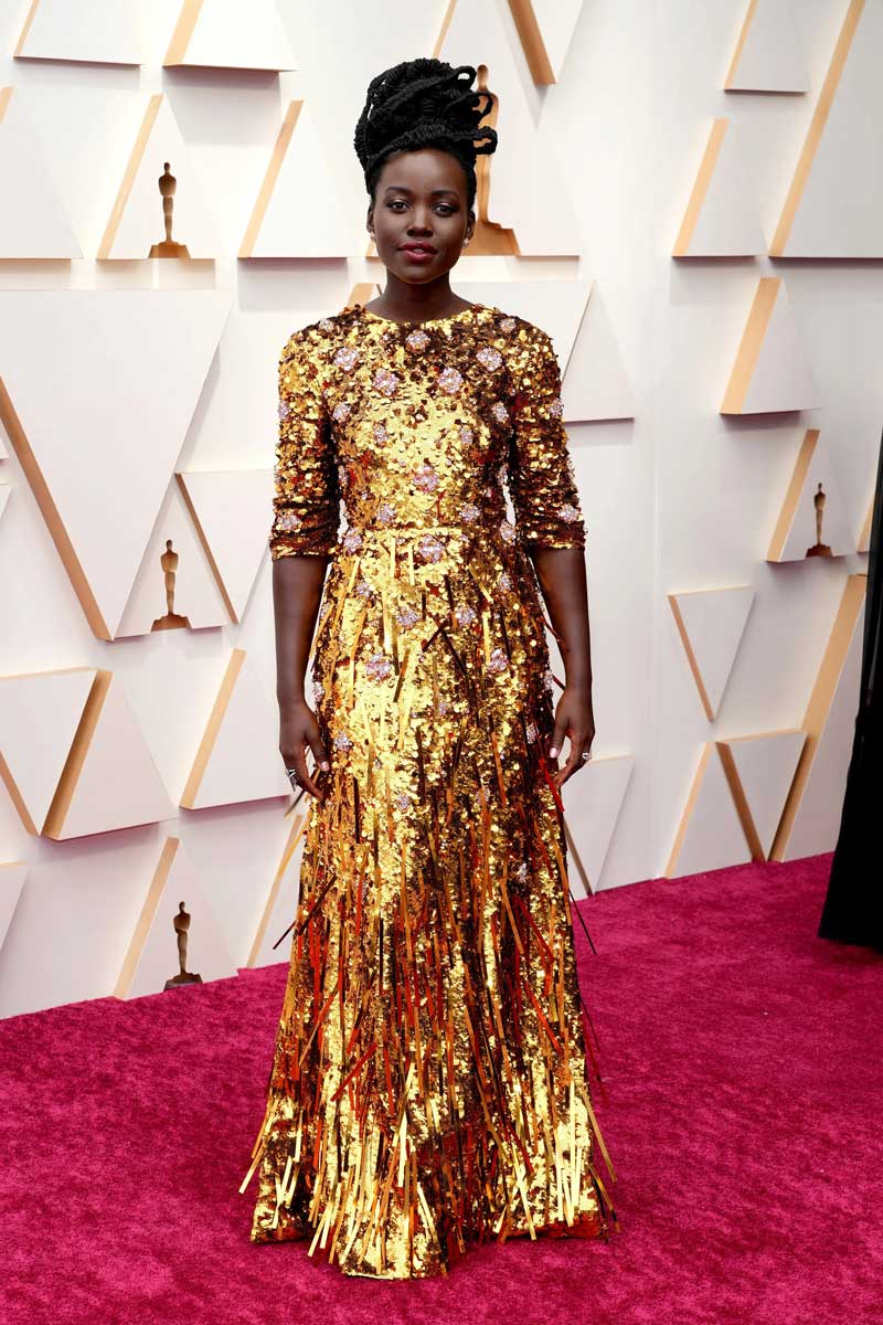Lupita Nyong'o glittering in gold on the 2022 Oscars red carpet.