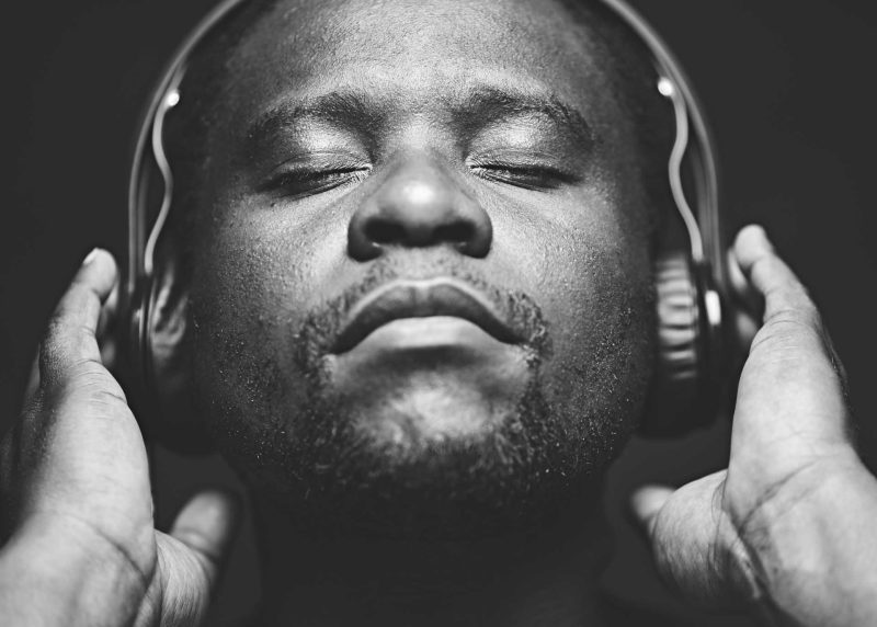 African Man wearing headphones while listening to music