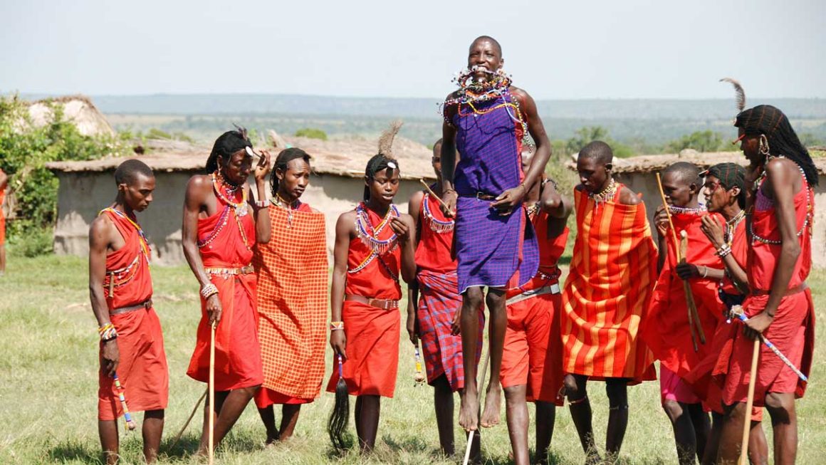 An image of Maasai men in a semi-circle during a traditional Maasai dance.