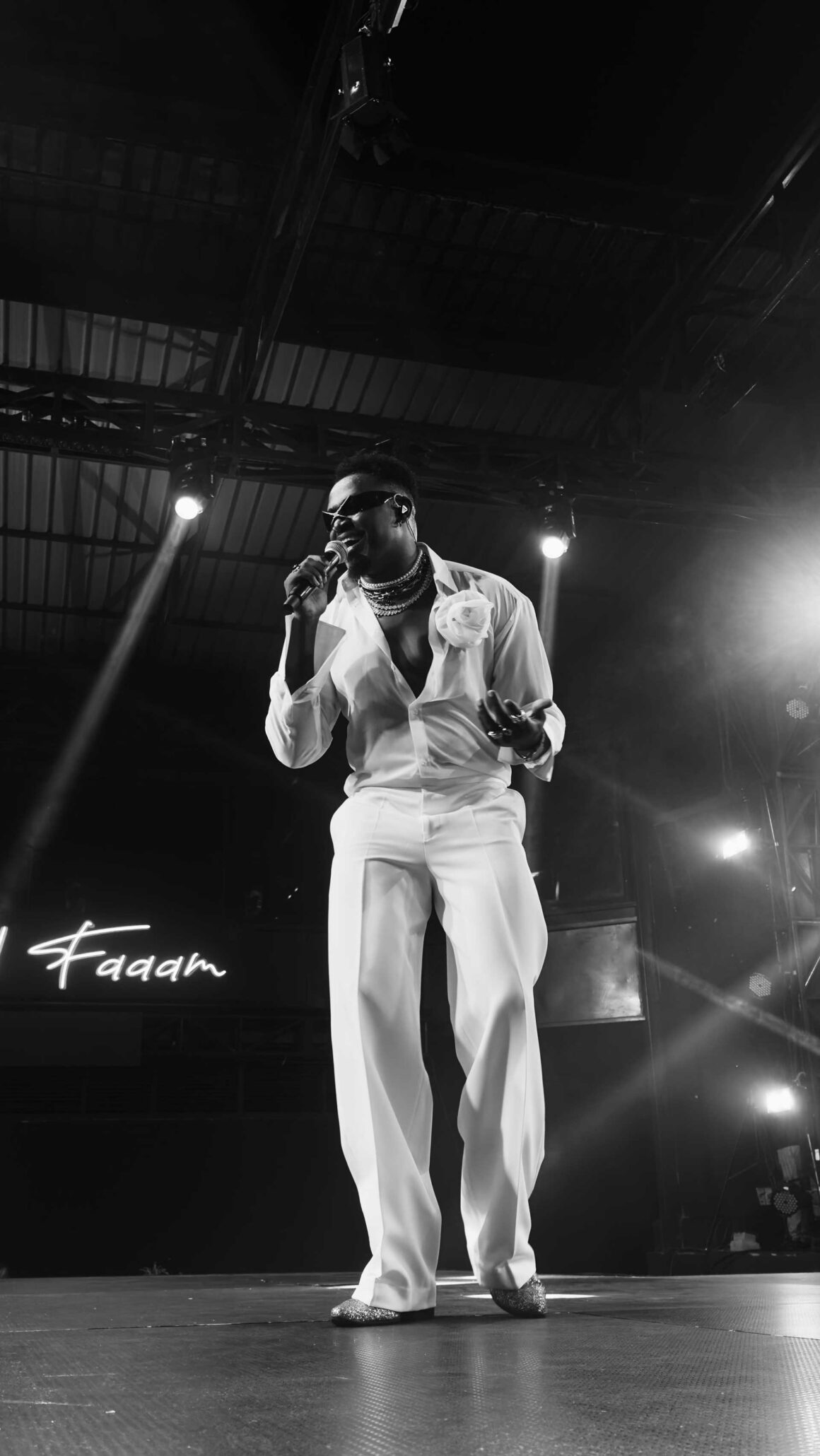 A monochrome image of Kenyan artist Okello Max performing on stage. Okello Max is one of the 7 artists who collectively make up KODONGKLAN. | image: KODONGKLAN